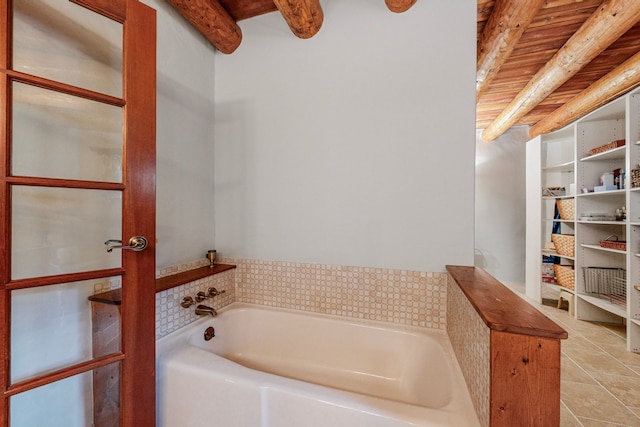 bathroom featuring beamed ceiling, a bathing tub, and tile patterned floors