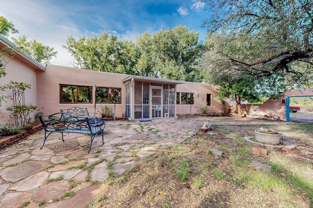 back of property featuring a sunroom and a patio area