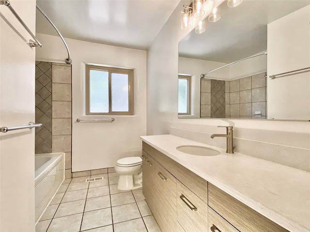 full bathroom with tile patterned flooring, vanity, toilet, and tiled shower / bath