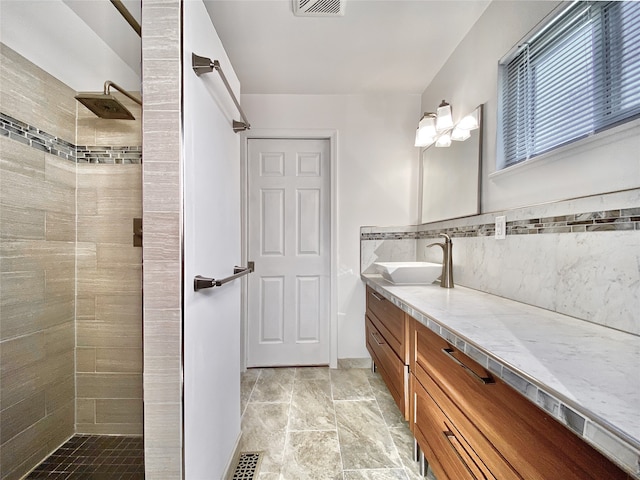 bathroom with vanity, tile walls, and tiled shower