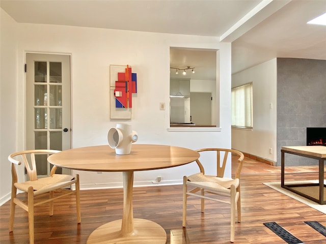 dining room featuring hardwood / wood-style floors and a fireplace