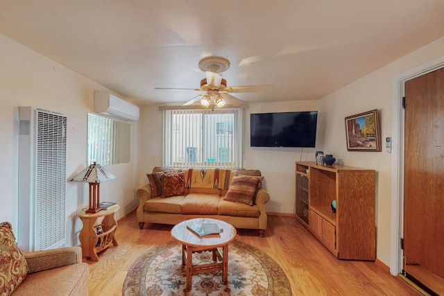 living room with light hardwood / wood-style floors, a wall mounted AC, and ceiling fan