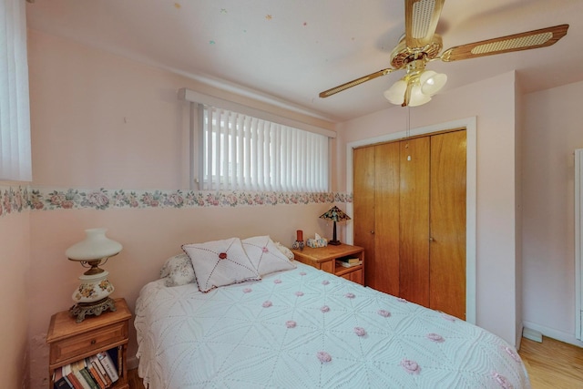 bedroom featuring hardwood / wood-style floors, ceiling fan, and a closet