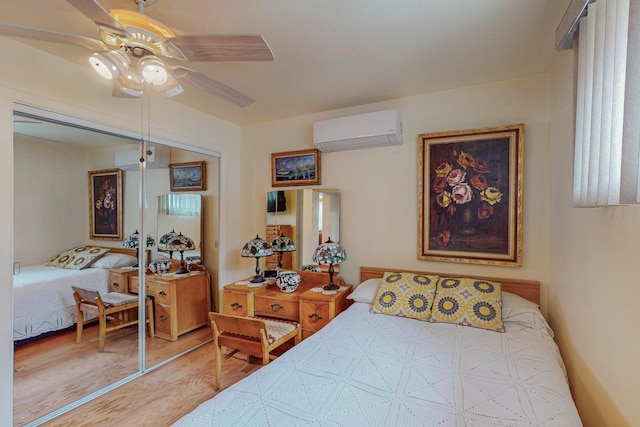 bedroom featuring wood-type flooring, a wall mounted AC, ceiling fan, and a closet