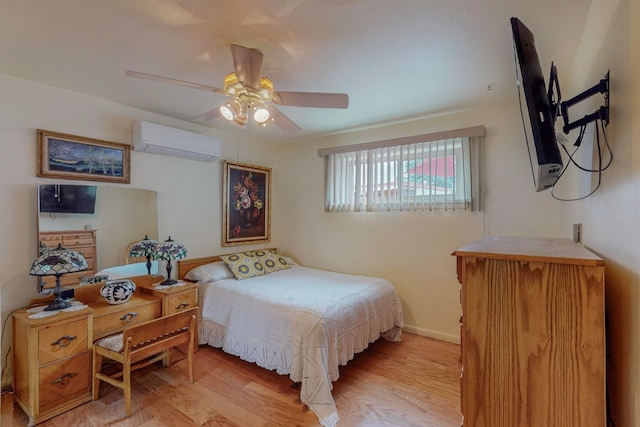 bedroom featuring ceiling fan, light hardwood / wood-style floors, and an AC wall unit