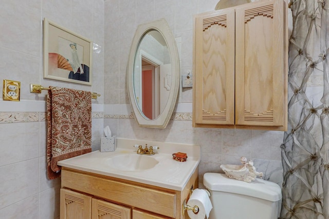 bathroom featuring tile walls, vanity, and toilet