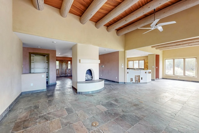 unfurnished living room featuring wooden ceiling, beam ceiling, ceiling fan, and high vaulted ceiling