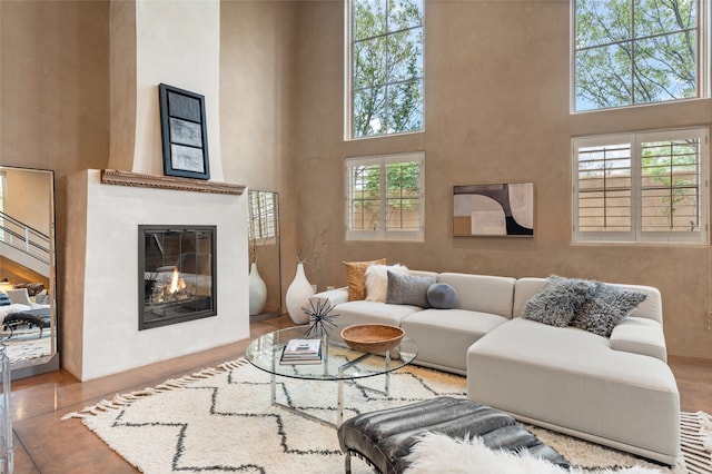 living room with a towering ceiling, hardwood / wood-style floors, and a healthy amount of sunlight