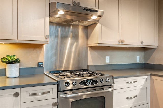 kitchen featuring white cabinets, gas range, and ventilation hood