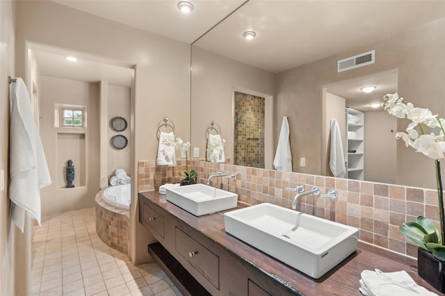 bathroom featuring tile patterned flooring, independent shower and bath, vanity, and backsplash