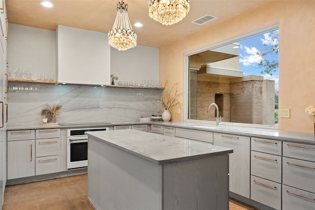 23 Lavadero Rd, Santa Fe, NM 87506 - kitchen with oven, visible vents, a sink, a center island, and a chandelier