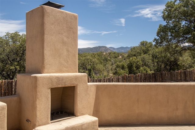 balcony featuring an outdoor fireplace and a mountain view