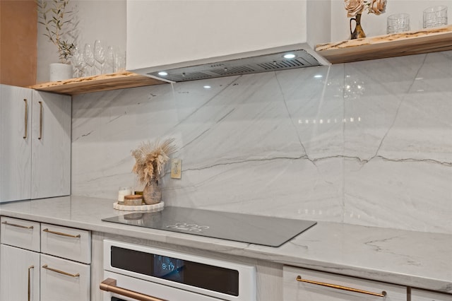 kitchen with light stone counters, white oven, white cabinets, and black electric stovetop