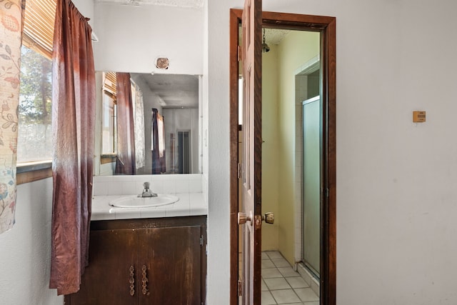 bathroom featuring tile patterned flooring, vanity, and an enclosed shower