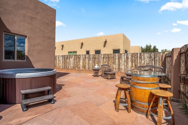 view of patio with a fenced backyard and a hot tub