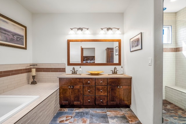 bathroom with vanity and tiled tub