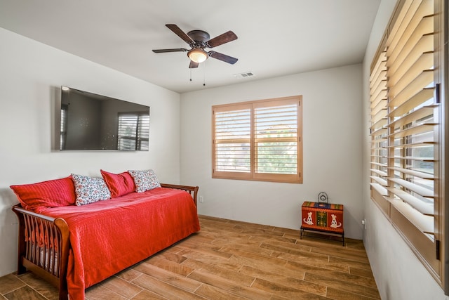 bedroom featuring ceiling fan, wood finished floors, and visible vents