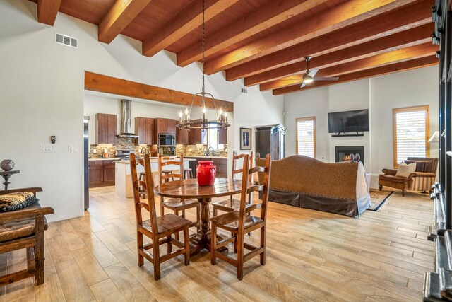 living room featuring light hardwood / wood-style floors, beam ceiling, and ceiling fan with notable chandelier