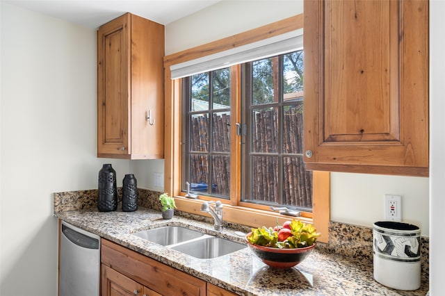 kitchen with dishwasher, light stone counters, and sink