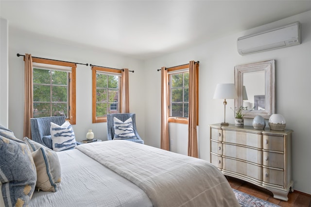 bedroom with dark wood-type flooring and a wall unit AC