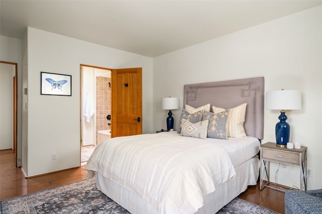 bedroom with ensuite bath and hardwood / wood-style flooring