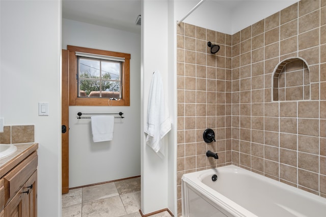 bathroom with tiled shower / bath and vanity