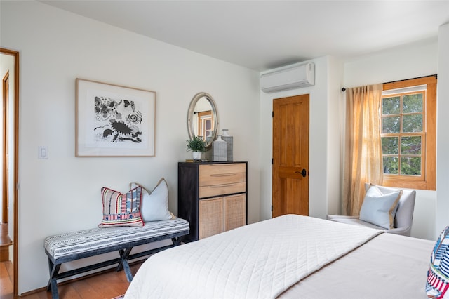 bedroom featuring hardwood / wood-style floors and a wall mounted AC