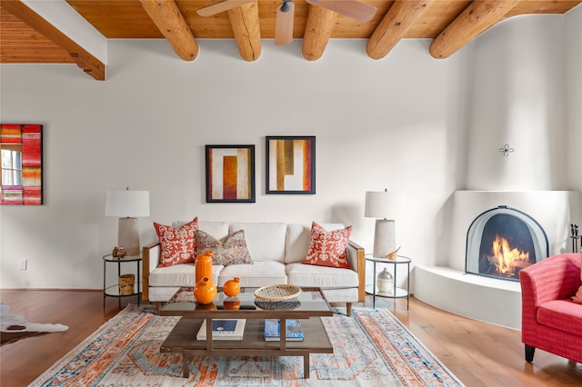 living room with wooden ceiling, beam ceiling, a fireplace, and hardwood / wood-style floors