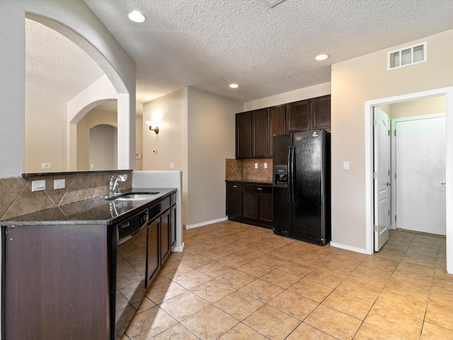 kitchen with visible vents, decorative backsplash, dark brown cabinets, black appliances, and a sink