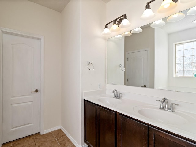 full bath with tile patterned flooring, a sink, baseboards, and double vanity