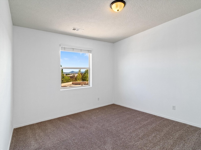 empty room featuring a textured ceiling, carpet flooring, visible vents, and baseboards