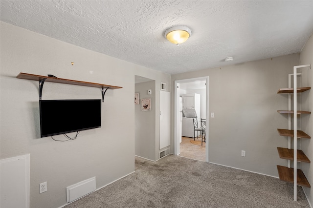 unfurnished living room with light carpet and a textured ceiling