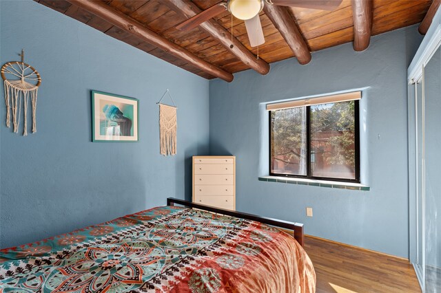 bedroom featuring wooden ceiling, beamed ceiling, ceiling fan, and hardwood / wood-style flooring