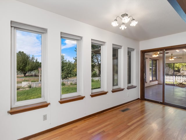 unfurnished sunroom featuring plenty of natural light and a notable chandelier