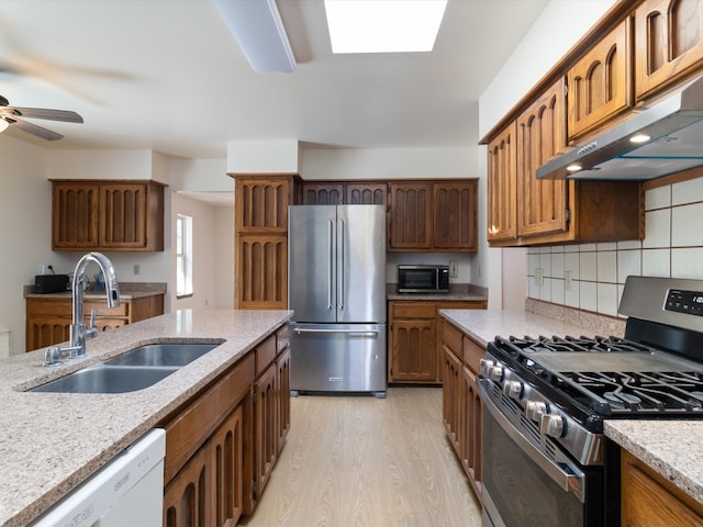 kitchen featuring ventilation hood, sink, light hardwood / wood-style flooring, tasteful backsplash, and stainless steel appliances