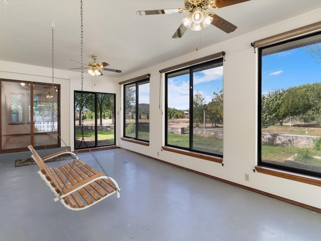 unfurnished sunroom with ceiling fan