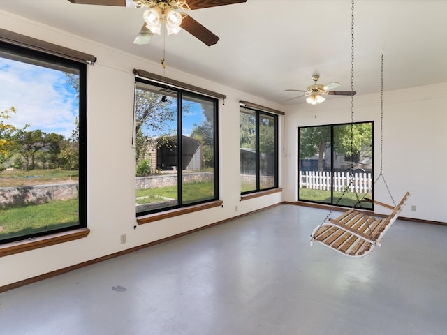 unfurnished sunroom with ceiling fan and a healthy amount of sunlight