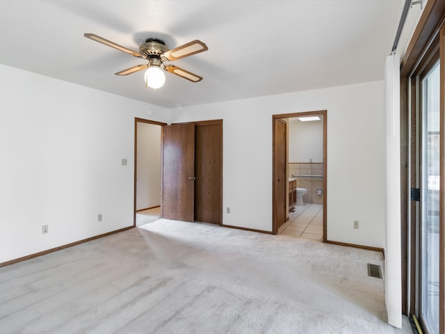 unfurnished bedroom featuring ceiling fan, light carpet, and connected bathroom