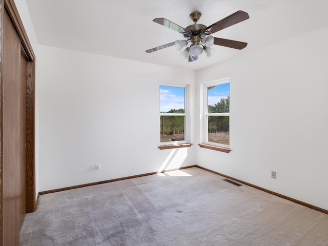 spare room featuring ceiling fan and light colored carpet