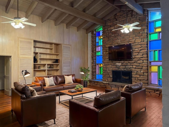 1017 River Rd, Santa Rosa, NM 88435 - living room with a ceiling fan, a fireplace, wooden walls, high vaulted ceiling, and wood ceiling with exposed beams