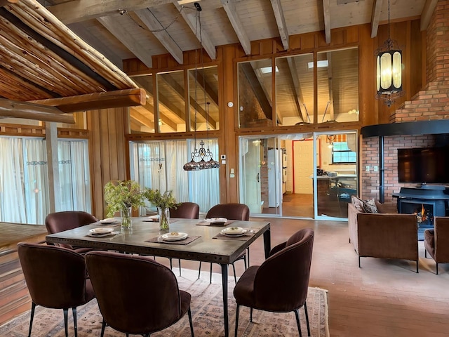 1017 River Rd, Santa Rosa, NM 88435 - dining space with beamed ceiling, wood walls, high vaulted ceiling, wood finished floors, and a chandelier