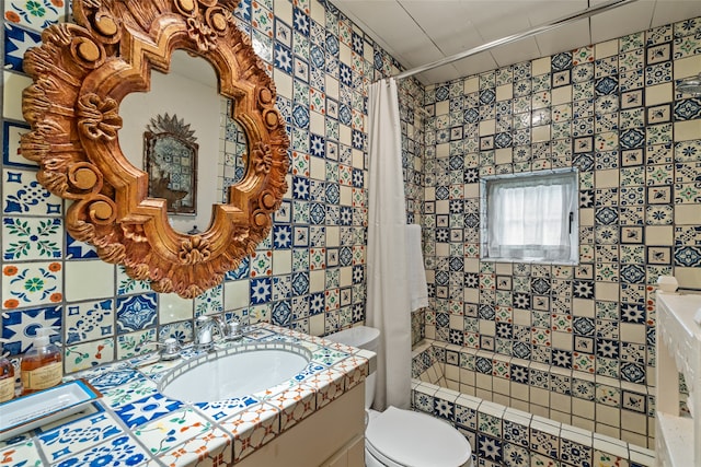 full bathroom with vanity, tile walls, toilet, and shower / bath combo