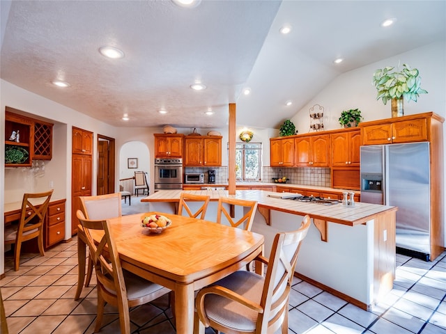 2176 La Tierra, Los Alamos, NM 87544 - dining space featuring vaulted ceiling, recessed lighting, light tile patterned floors, a toaster, and arched walkways