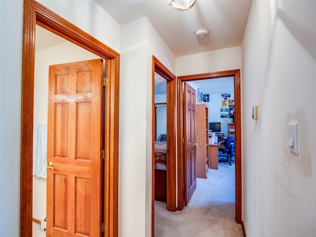 hallway featuring light colored carpet