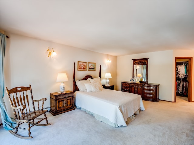 bedroom with light colored carpet, a walk in closet, and a closet