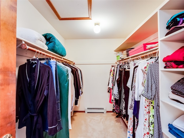 walk in closet with a baseboard radiator and light carpet