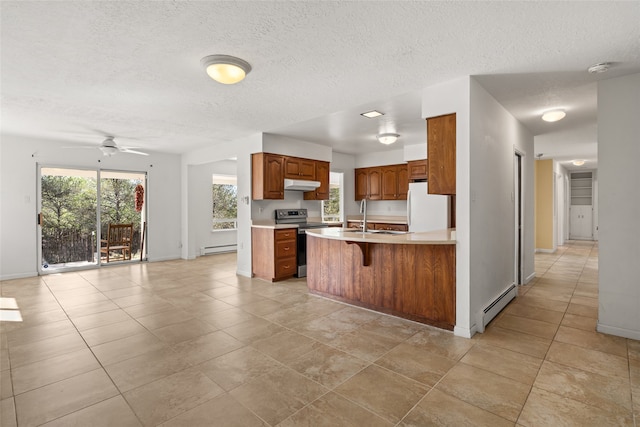 kitchen with white refrigerator, a textured ceiling, ceiling fan, stainless steel range with electric cooktop, and a baseboard heating unit