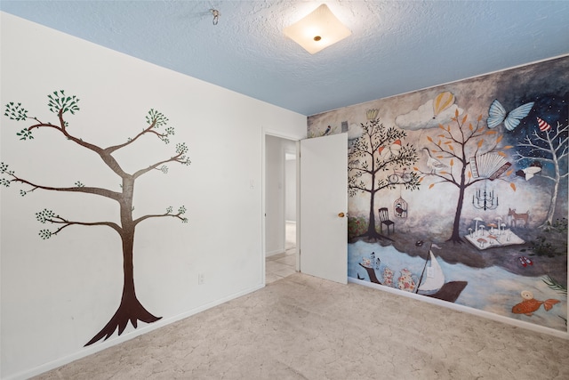 carpeted empty room featuring a textured ceiling