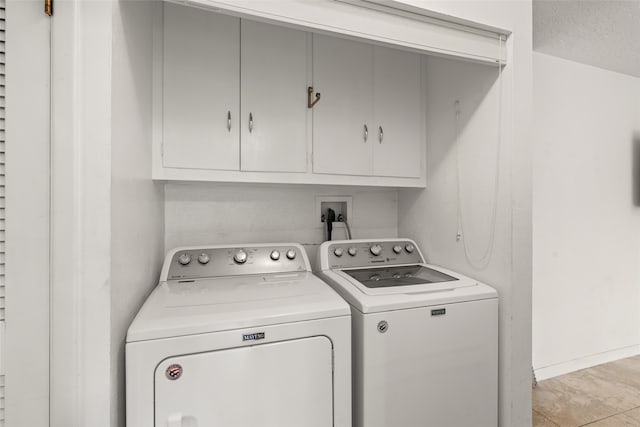 washroom featuring cabinets, a textured ceiling, light tile patterned floors, and washing machine and dryer