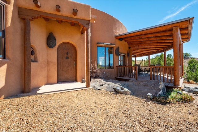 property entrance featuring a wooden deck and a patio area